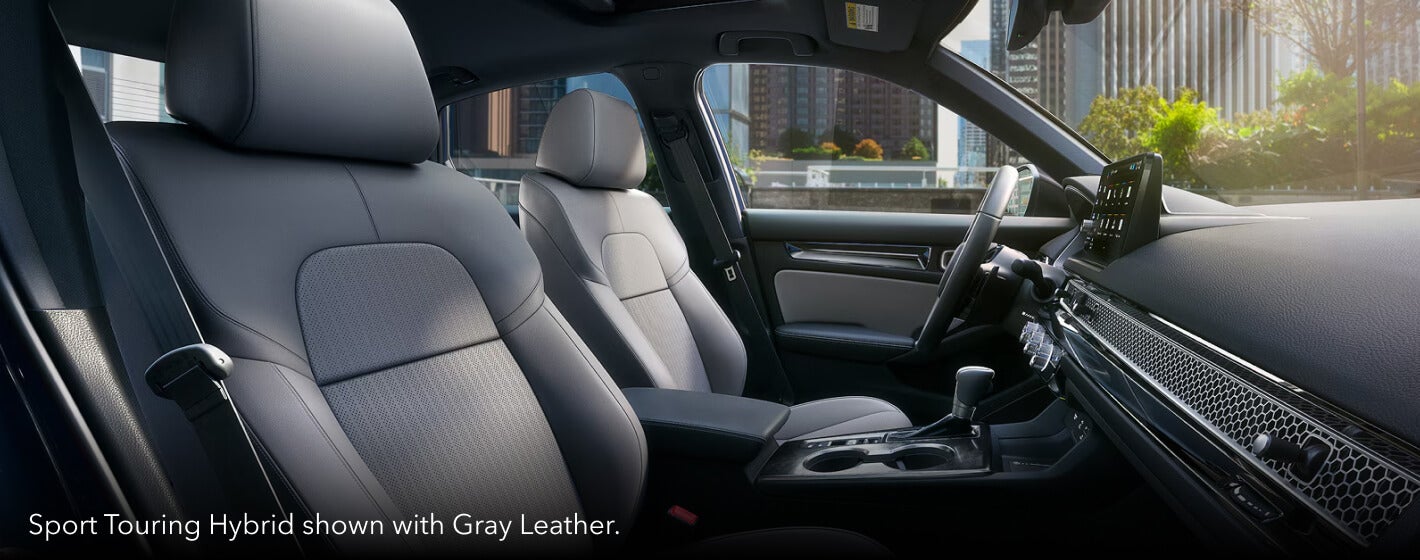 Perspective shot showing the front seats of the 2026 Honda Civic Sport Touring Hybrid with Great Leather seats.